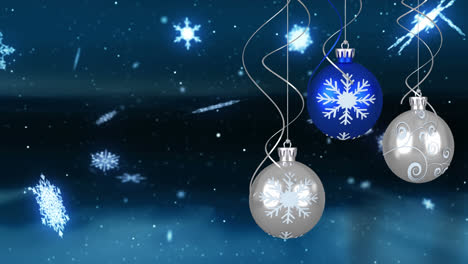 Animation-of-snowflakes-falling-over-christmas-baubles-decoration-in-winter-landscape