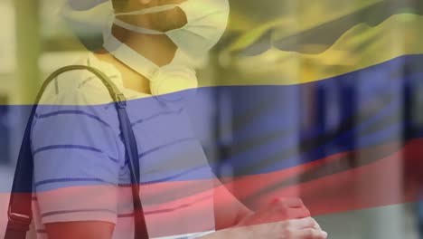 Animation-Der-Flagge-Kolumbiens,-Die-Während-Der-Covid-19-Pandemie-über-Einem-Mann-Mit-Gesichtsmaske-Weht