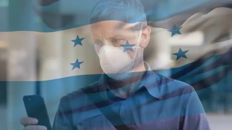 Animation-of-flag-of-honduras-waving-over-caucasian-man-wearing-face-mask-in-city-street