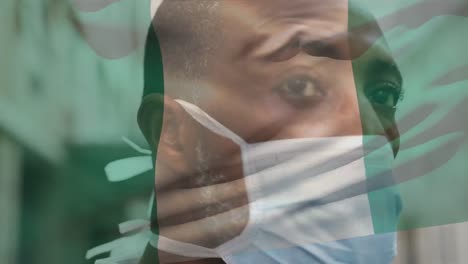 Animation-Der-Flagge-Nigerias,-Die-Während-Der-Covid-19-Pandemie-über-Einem-Mann-Mit-Gesichtsmaske-Weht