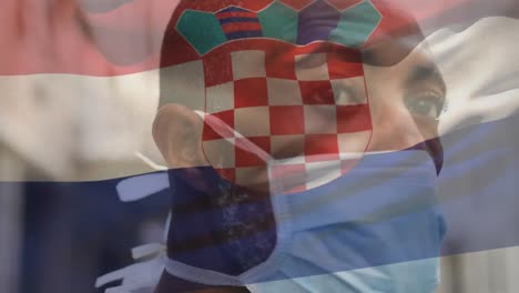 Animation-of-flag-of-croatia-waving-over-african-american-man-wearing-face-mask-in-city-street