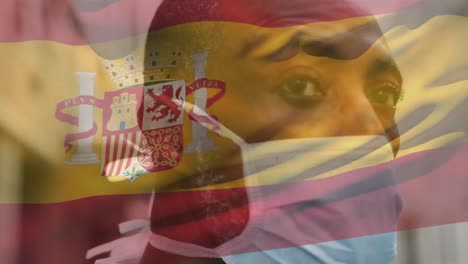 Animation-of-flag-of-spain-waving-over-man-wearing-face-mask-during-covid-19-pandemic