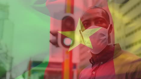 Animation-Der-Flagge-Kameruns,-Die-über-Einem-Afroamerikanischen-Mann-Mit-Gesichtsmaske-In-Der-Stadtstraße-Winkt
