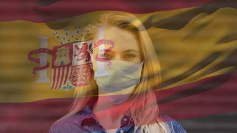 Animation-of-flag-of-spain-waving-over-caucasian-woman-wearing-face-mask-in-city-street