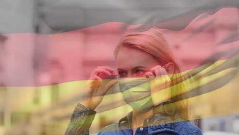 Animation-of-flag-of-germany-waving-over-woman-wearing-face-mask-during-covid-19-pandemic