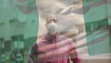 Animation-Der-Flagge-Nigerias,-Die-Während-Der-Covid-19-Pandemie-über-Einem-Mann-Mit-Gesichtsmaske-Weht