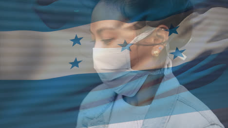 Animation-of-flag-of-honduras-waving-over-woman-wearing-face-mask-during-covid-19-pandemic