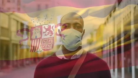 Animation-of-flag-of-spain-waving-over-man-wearing-face-mask-during-covid-19-pandemic