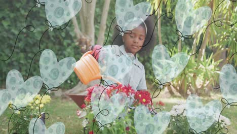 Animation-Von-Herzballons-über-Einem-Afroamerikanischen-Mädchen,-Das-Pflanzen-Im-Garten-Gießt