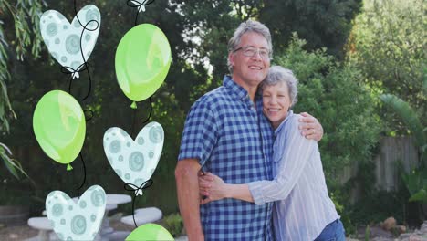 Animation-of-balloons-over-smiling-caucasian-grandparents-hugging-in-garden