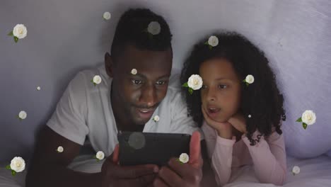 Animation-Von-Rosen-über-Einem-Glücklichen-Afroamerikanischen-Vater-Und-Seiner-Tochter,-Die-Ein-Tablet-Im-Bett-Benutzen