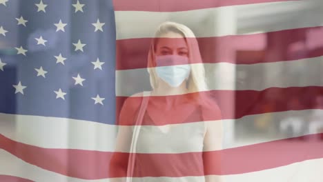 Animation-of-flag-of-usa-waving-over-caucasian-woman-wearing-face-mask-in-city-street