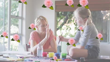 Animation-of-roses-over-happy-caucasian-mother-and-daughter-painting-together