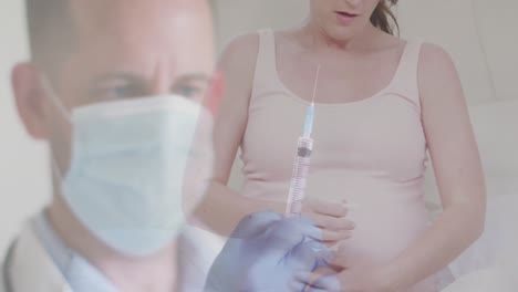Animation-of-male-doctor-holding-covid-19-vaccine-over-pregnant-woman