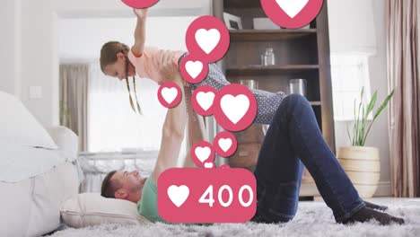 Animation-of-heart-icons-and-number-over-caucasian-father-and-daughter-playing-in-bedroom