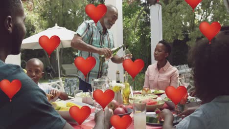 Animation-oh-heart-balloons-over-happy-african-american-family-dining-in-garden