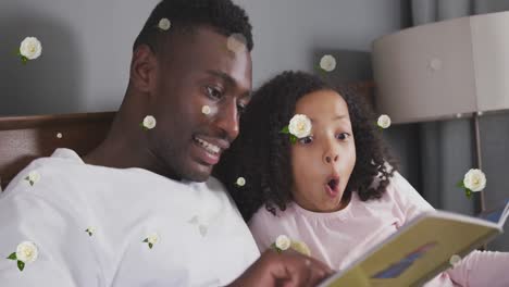 Animation-of-roses-over-happy-african-american-father-and-daughter-reading-book