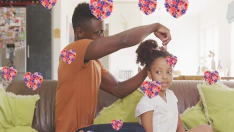 Animation-of-flower-hearts-over-african-american-father-combing-hair-to-his-daughter