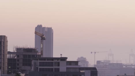 General-view-of-cityscape-with-multiple-buildings,-construction-site-and-shipyard-covered-in-fog