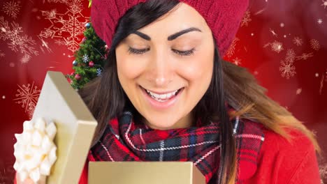 Animation-of-happy-caucasian-woman-opening-present-over-christmas-tree-on-red-background