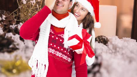 Animation-of-happy-caucasian-couple-wearing-santa-hats-over-christmas-decorations