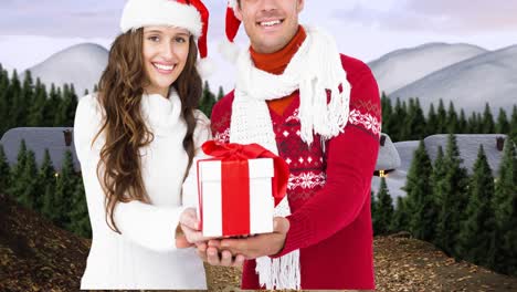 Animation-of-happy-caucasian-couple-wearing-santa-hats-keeping-present-over-winter-scenery