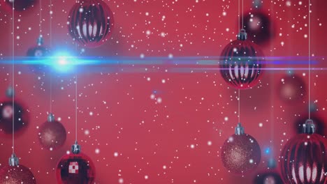 Animation-of-snow-falling-over-christmas-baubles-on-red-background