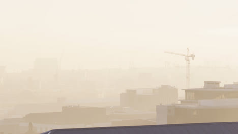 General-view-of-cityscape-with-buildings-and-construction-site-covered-in-fog