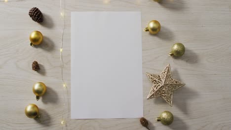 Video-of-christmas-decorations-with-white-card-and-copy-space-on-wooden-background