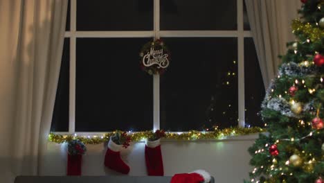 Video-of-christmas-greetings,-decorations,-christmas-tree,-lights-and-christmas-stockings-at-home