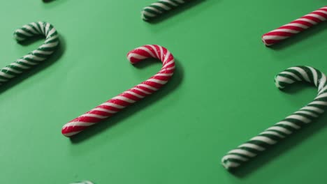 Red-and-green-striped-candy-canes-on-green-background
