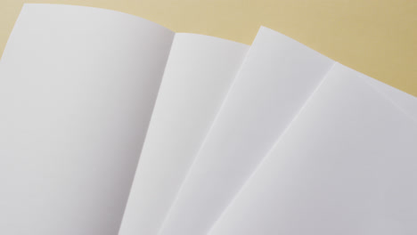 Video-of-white-sheets-of-paper-with-copy-space-on-yellow-background