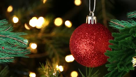 Animation-of-red-bauble-hanging-on-christmas-tree
