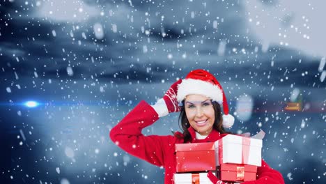 Animation-of-snow-falling-over-happy-caucasian-woman-wearing-santa-hat-keeping-presents