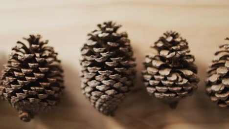 Video-of-a-row-of-pine-cones-on-wooden-background