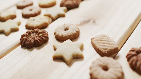 Video-of-assorted-tasty-christmas-cookies-on-pale-wooden-background