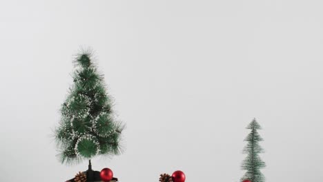 Video-of-christmas-decorations-with-christmas-trees-and-copy-space-on-white-background
