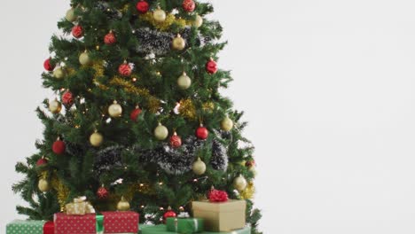 Video-of-christmas-tree-decorated-with-baubles-on-white-background