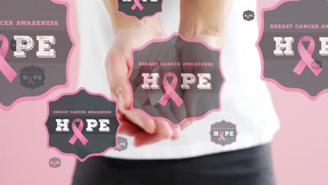 Animation-of-hope-text-with-hands-of-woman-holding-pink-breast-cancer-ribbon,-on-pink-background