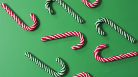 Red-and-green-striped-candy-canes-on-green-background