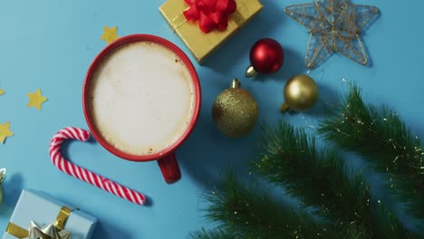 Video-of-christmas-decorations-with-coffee-and-presents-on-blue-background