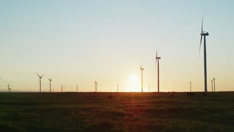 Wind-turbines-in-countryside-landscape-with-cloudless-sky-at-sunset