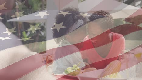 Animation-of-american-flag-over-happy-african-american-family-having-dinner-and-smiling