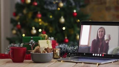 Happy-caucasian-senior-woman-on-video-call-on-laptop,-with-christmas-decorations-and-tree