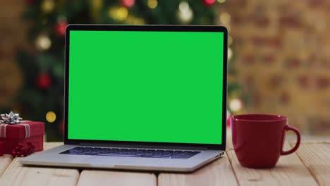 Laptop-Mit-Grünem-Bildschirm-Auf-Dem-Bildschirm,-Mit-Weihnachtsdekorationen-Und-Baum