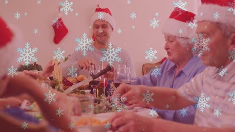 Animation-of-snow-falling-over-smiling-caucasian-family-with-santa-hats-having-dinner