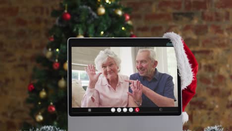 Kaukasisches-Seniorenpaar-Winkt-Bei-Videoanruf-Am-Computer,-Mit-Weihnachtsbaum