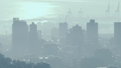 General-view-of-cityscape-with-multiple-modern-buildings-and-shipyard-covered-in-smog