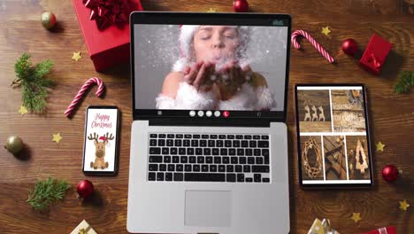 Kaukasische-Frau-Im-Weihnachtsmannkostüm-Bei-Videoanruf-Auf-Laptop,-Mit-Smartphone,-Tablet-Und-Dekorationen