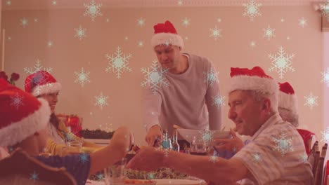 Animation-Von-Schnee,-Der-über-Eine-Lächelnde-Kaukasische-Familie-Mit-Weihnachtsmützen-Beim-Abendessen-Fällt